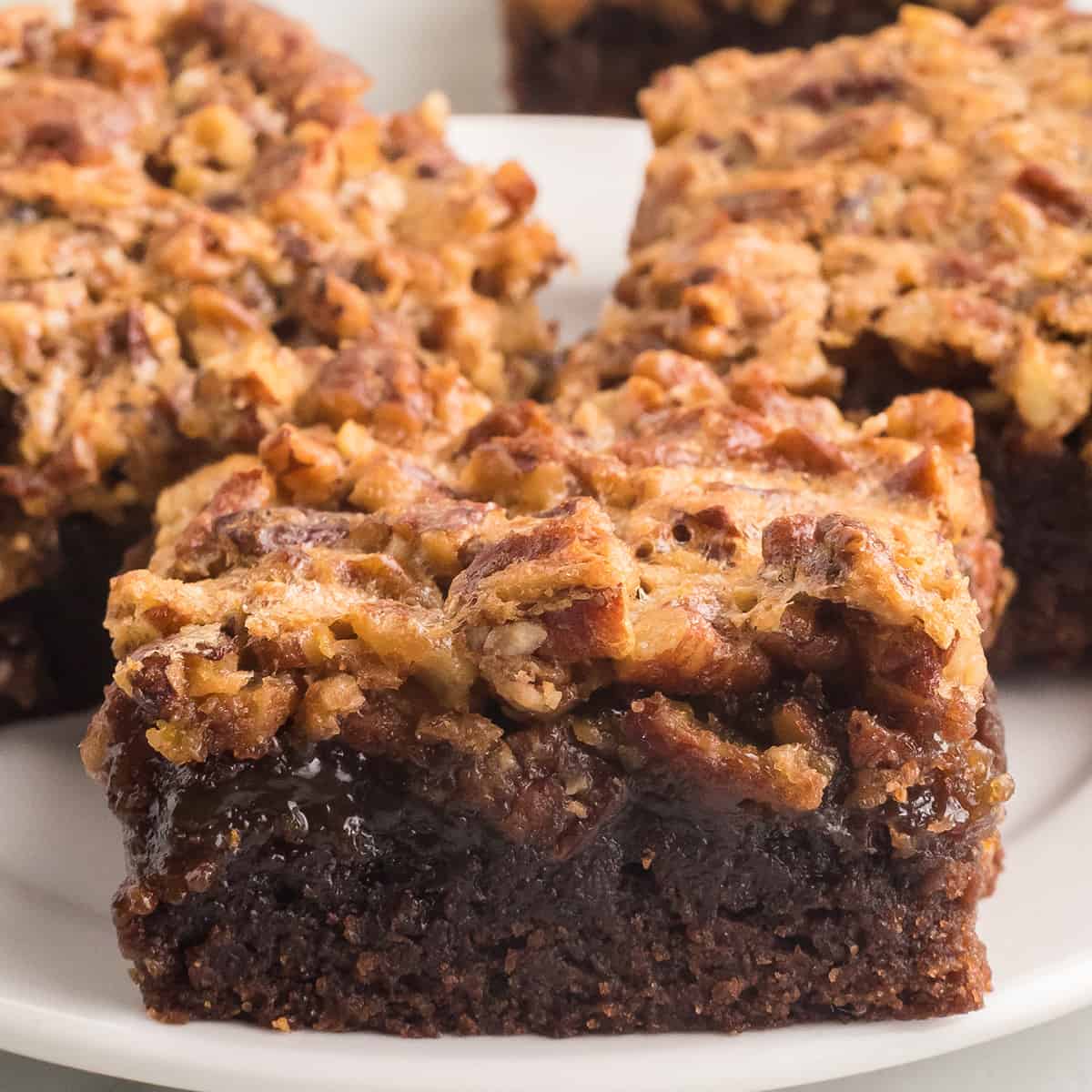 A brownie square on a white plate.