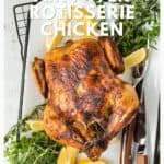 Whole roasted chicken on a platter with herbs, lemon wedges, and serving utensils; text overlay present.