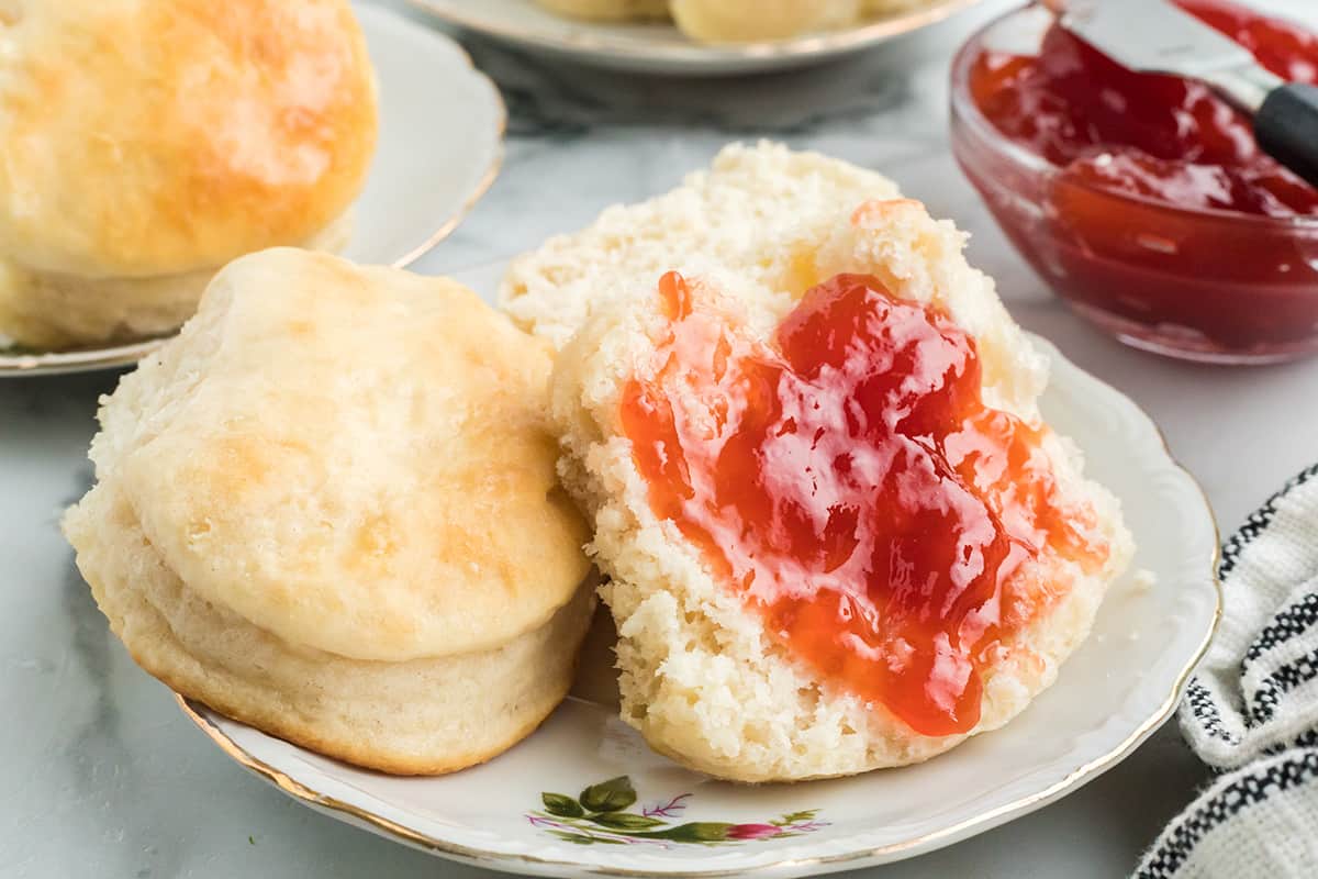 A biscuit split open and spread with jam.