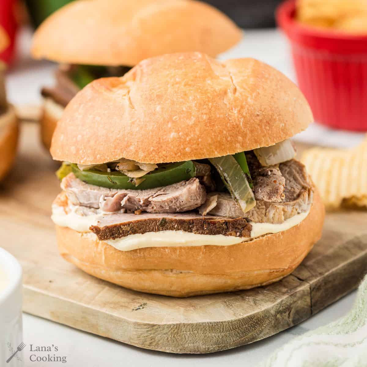 Two pork tenderloin sandwiches on a wooden board.