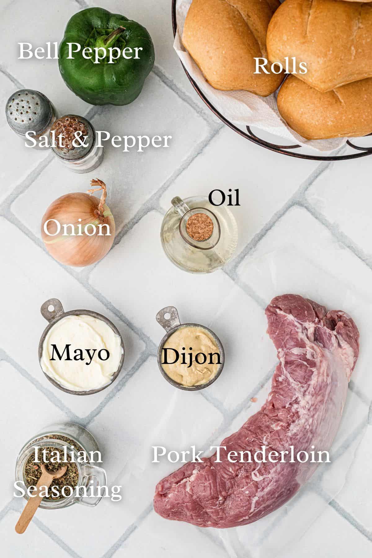 Ingredients for roasted pork tenderloin sandwich in separate containers on a tile background