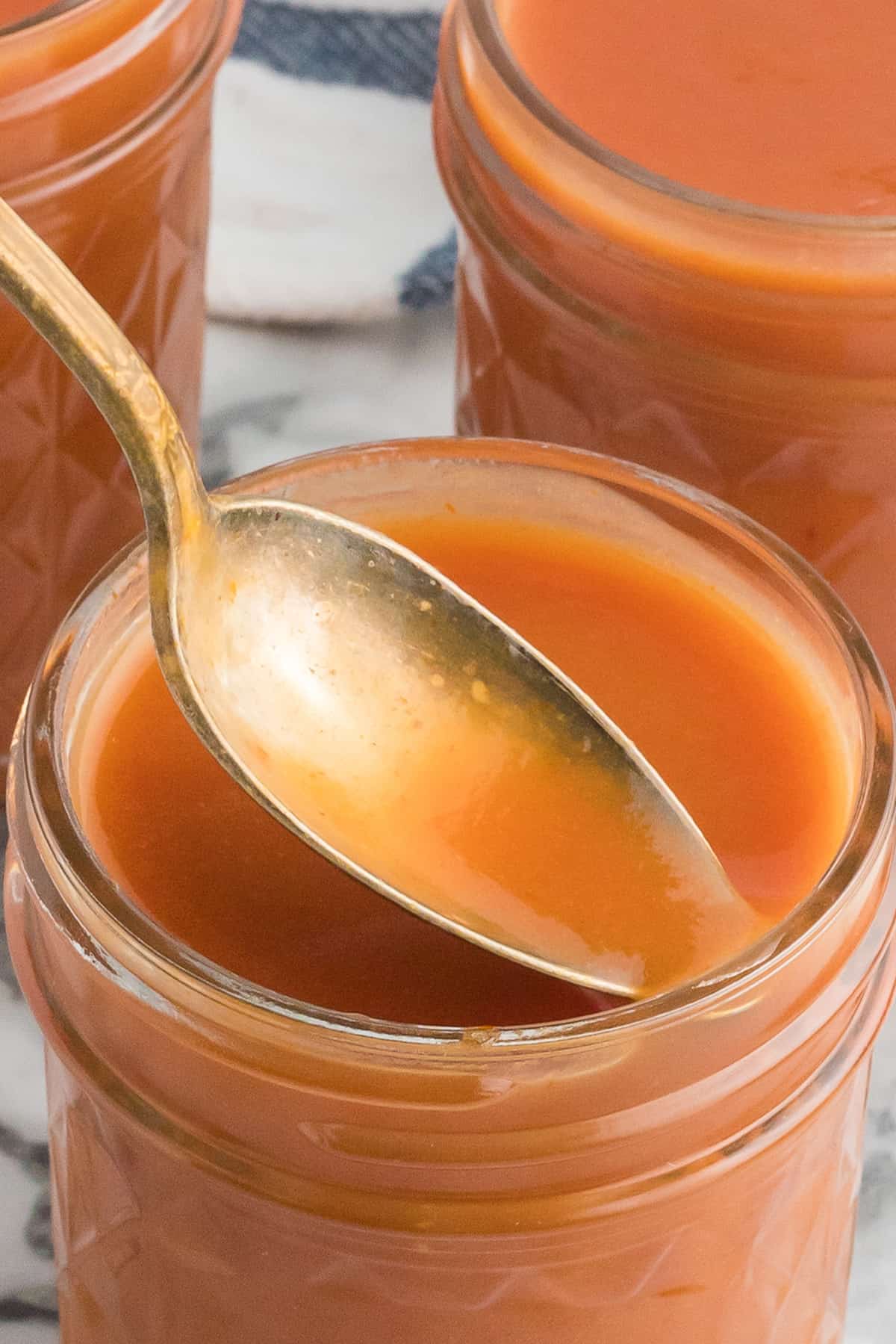 Finished sauce in a small jar with a spoon.
