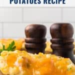 Baked potatoes stuffed with ham and melted cheese, with two pepper mills in the background.