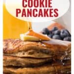 Stack of oatmeal pancakes topped with butter and syrup, with blueberries and orange juice in the background.