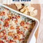 A dish of turnip green dip with bacon in a white pan, served with chips on the side.