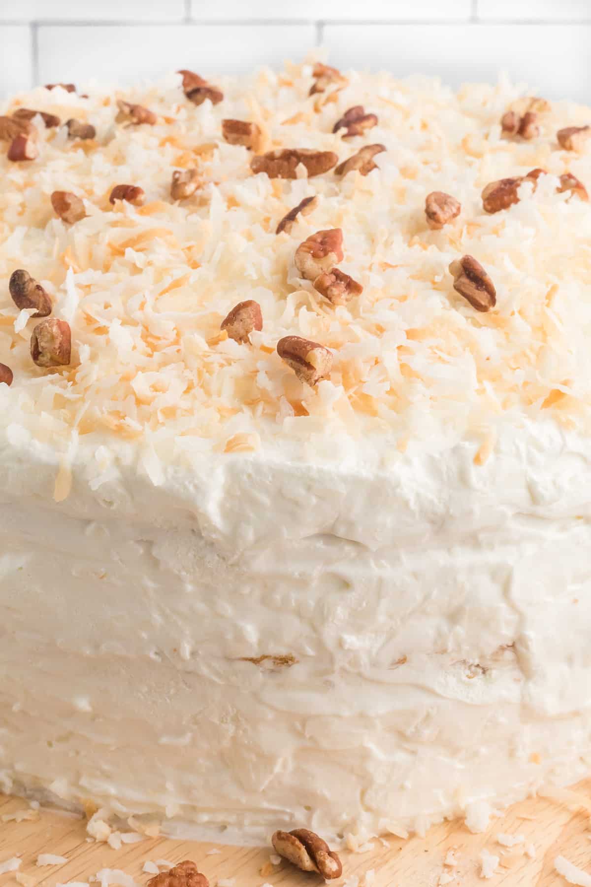 Finished cake with toasted coconut and pecan garnishes.