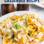 A plate of creamy ham and noodle casserole topped with chopped parsley, with text overlay and website link.