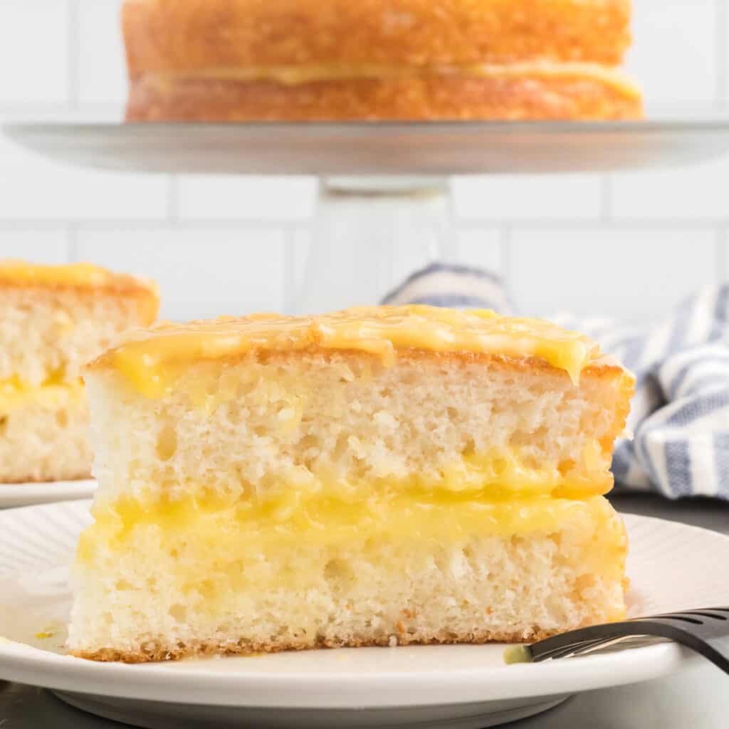 A slice of lemon cheese cake on a serving plate.