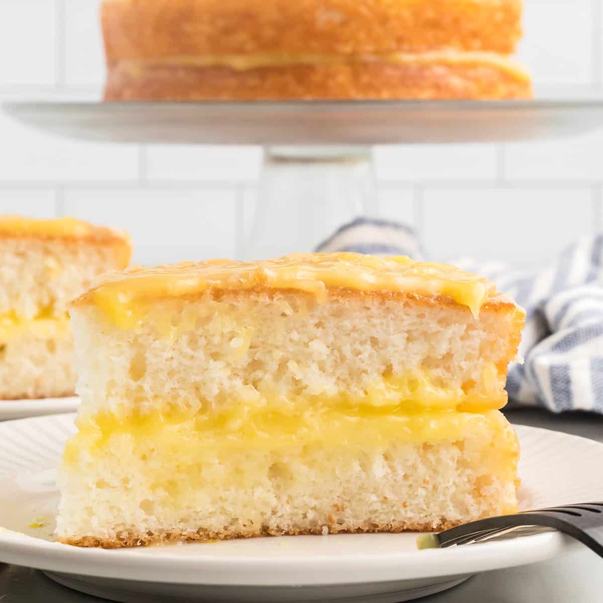 A slice of lemon cheese cake on a serving plate.