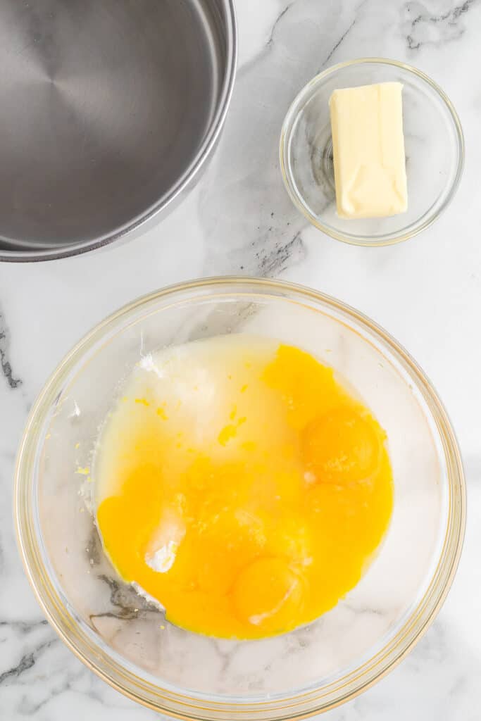 Egg yolks added to sugar in a bowl.