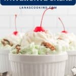 Three ramekins of green Watergate salad topped with whipped cream, cherries, and walnuts on a white surface.