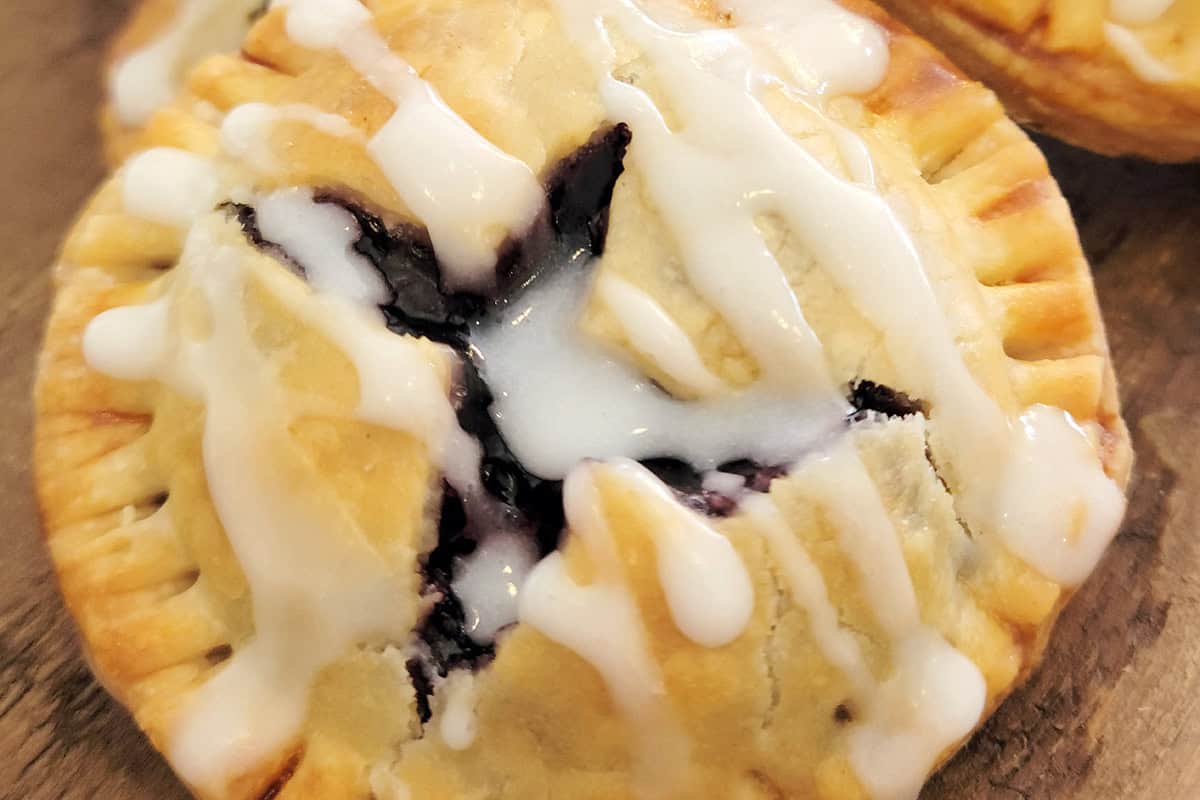 A blueberry pie cookie with glaze on top.