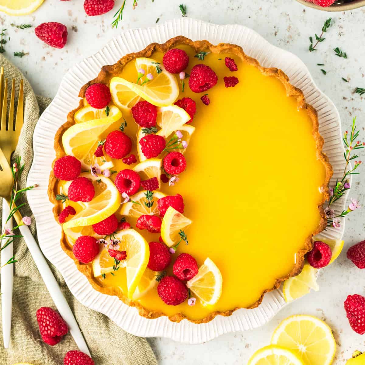 Lemon raspberry tart on a white plate.