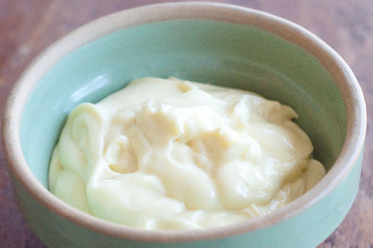 Homemade mayonnaise in a vintage green bowl.