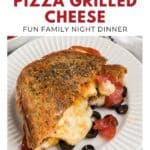Close-up of pepperoni pizza grilled cheese on a white plate with olives, topped with herbs.