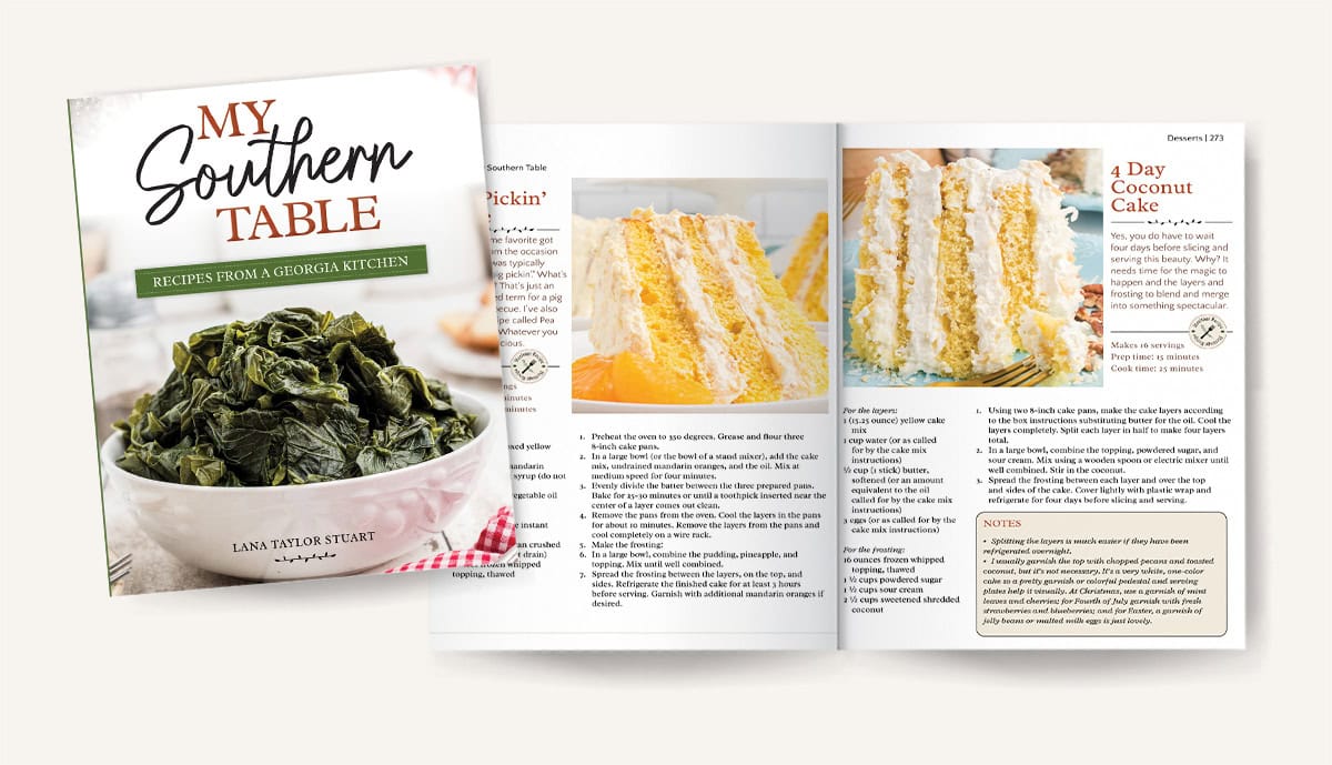 Open cookbook with a greens dish on the cover and a coconut cake recipe on the visible inside pages.