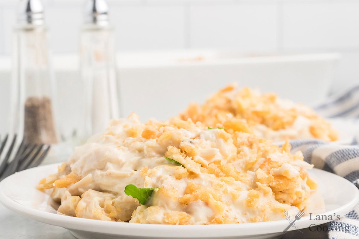 A plate of creamy chicken casserole topped with crunchy crumbs, with salt and pepper shakers in the background.