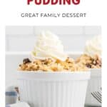 White ramekin of baked rice pudding with whipped cream on top, placed on a white table with a striped napkin.