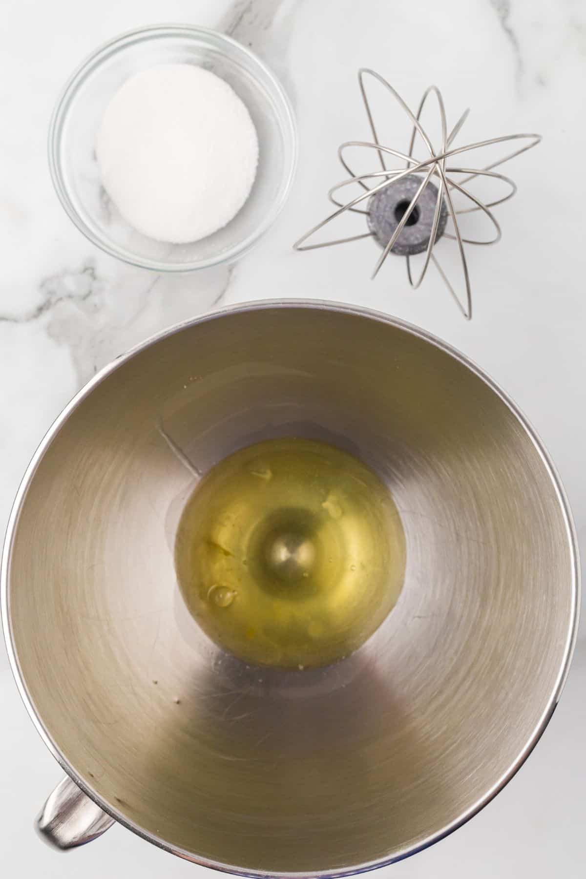 Egg whites in the bottom of a mixing bowl before being whipped.