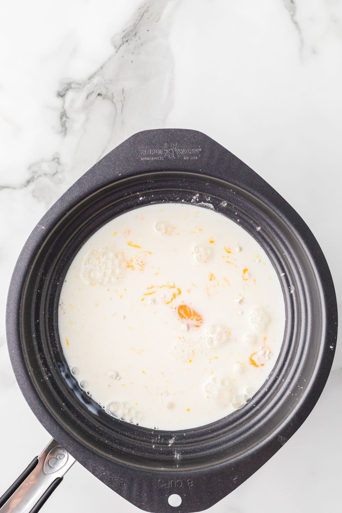 Eggs blended into the sugar and flour mixture with milk added to a double boiler.