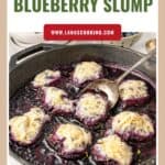 A skillet of stovetop blueberry slump topped with dumplings, with a spoon lifting one dumpling.