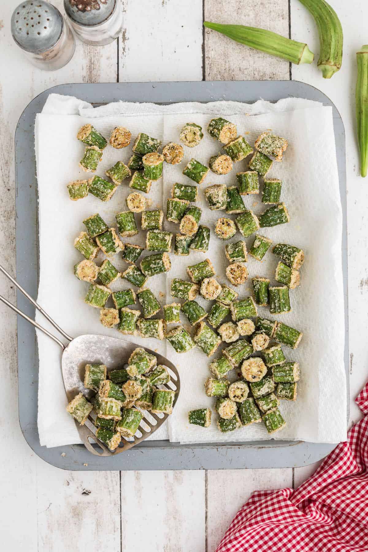 Fried okra draining on paper towels.