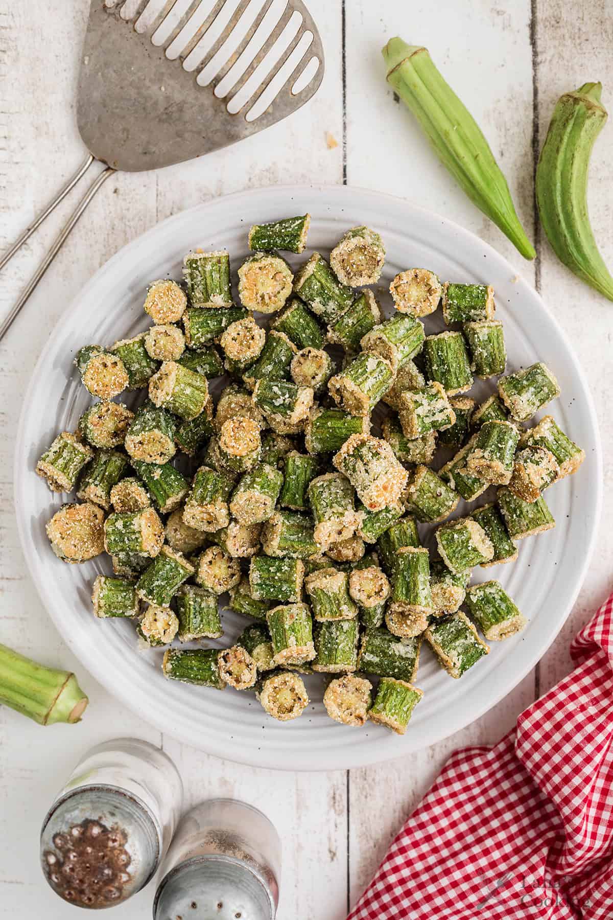 Finished fried okra on a white serving plate.
