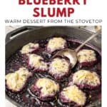 A cast iron skillet with blueberry slump dessert and spoon, topped with golden biscuit-like dumplings.