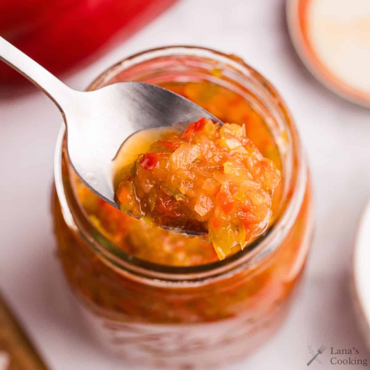 Sweet pepper relish with a spoonful taken out.