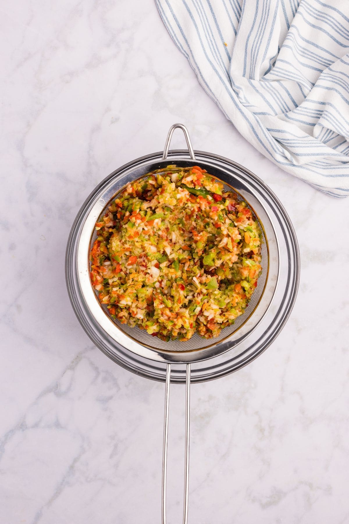 Chopped vegetables draining in a colander.