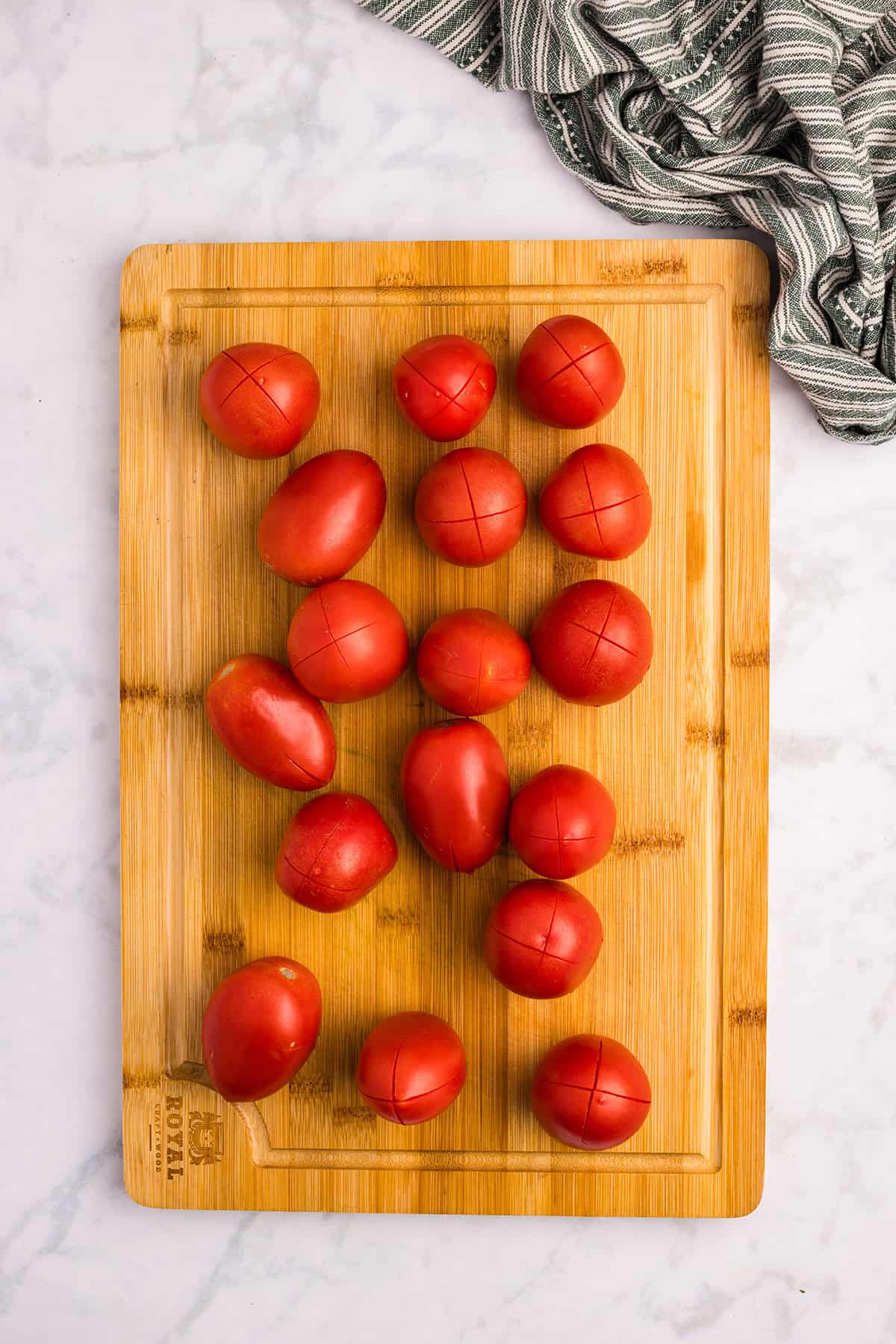 Tomatoes with a cross cut in the bottom of each.