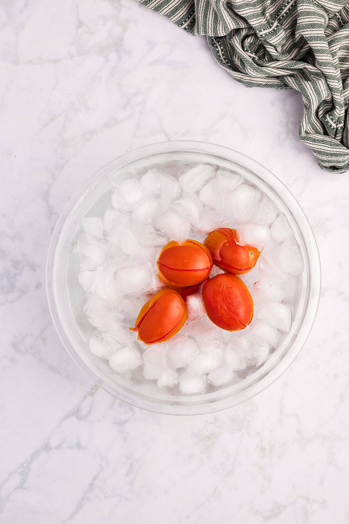Tomatoes being quickly cooled in ice and water.