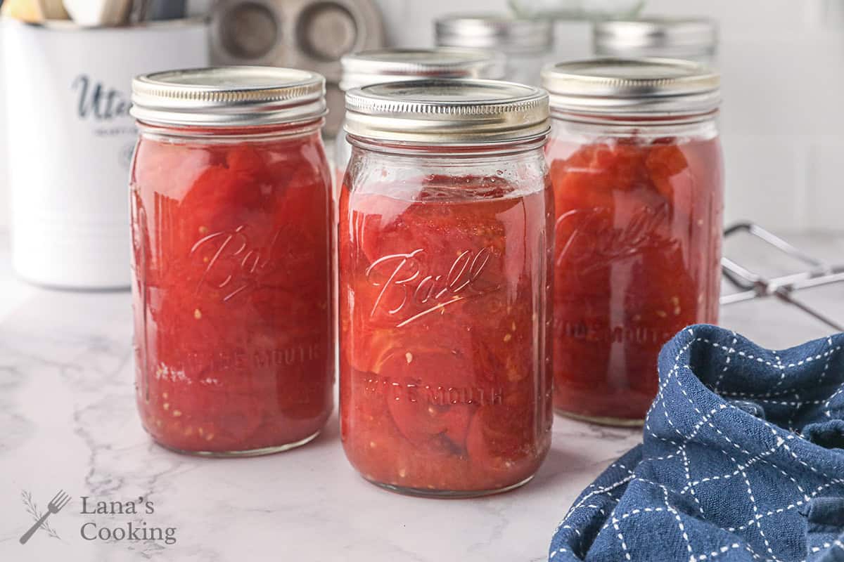 Finished mason jars of canned tomatoes.