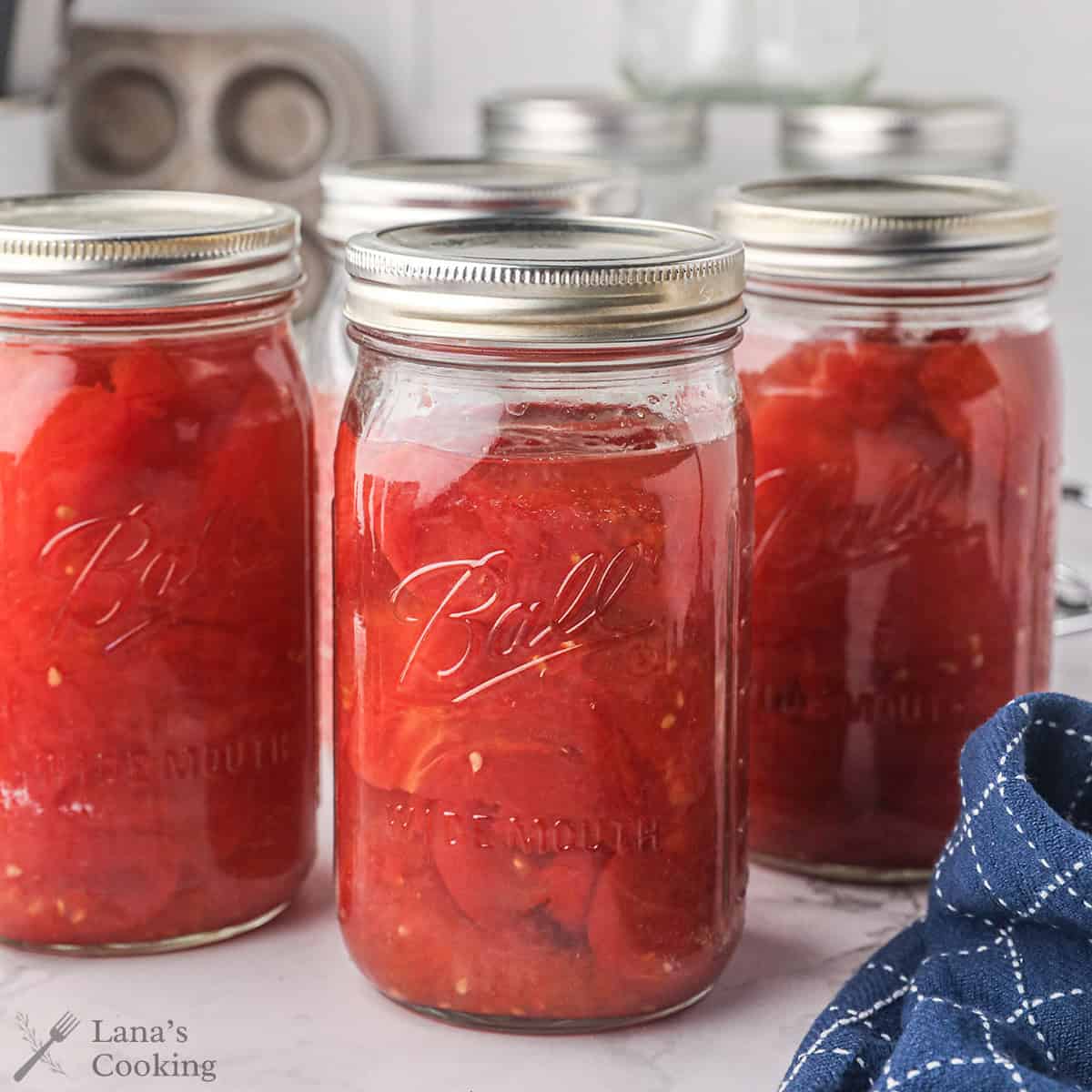Finished mason jars of canned tomatoes.