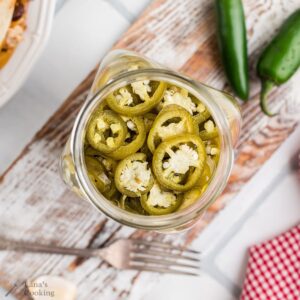 A pint jar filled with pickled jalapenos.
