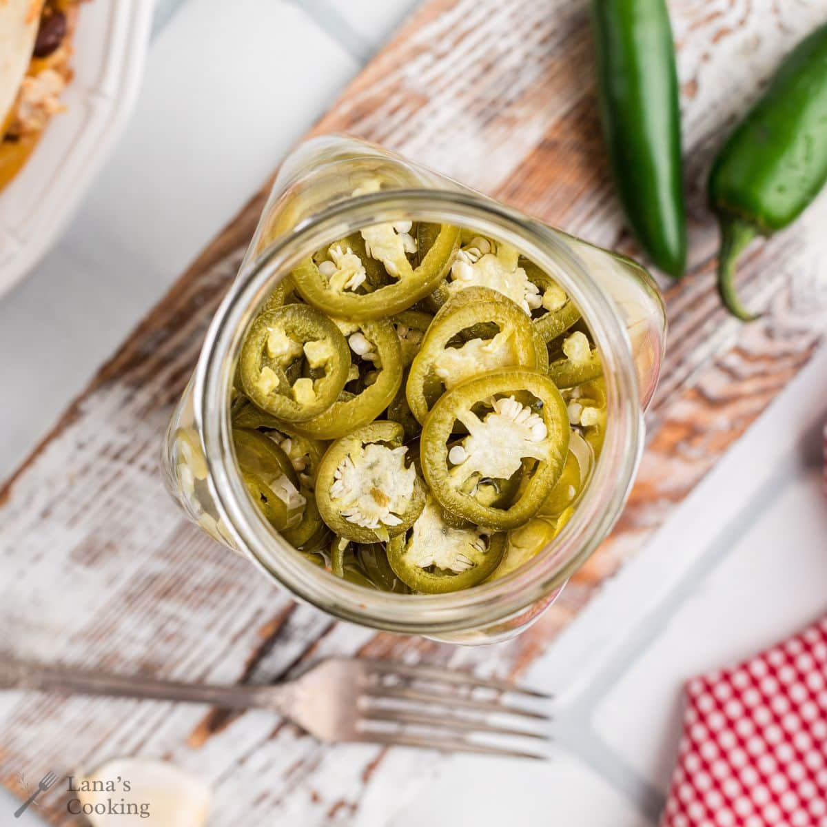 A pint jar filled with pickled jalapenos.