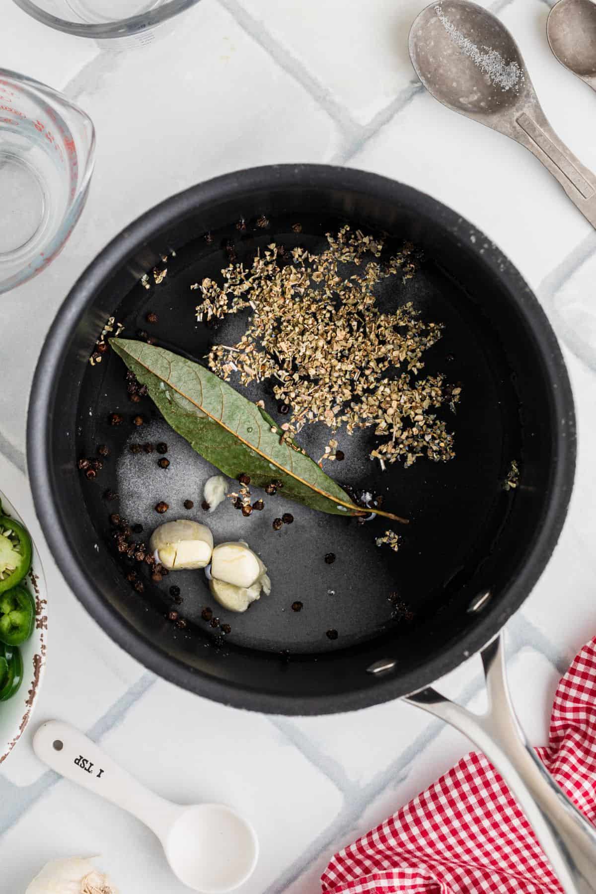 Brine ingredients in a saucepan on a tile background.