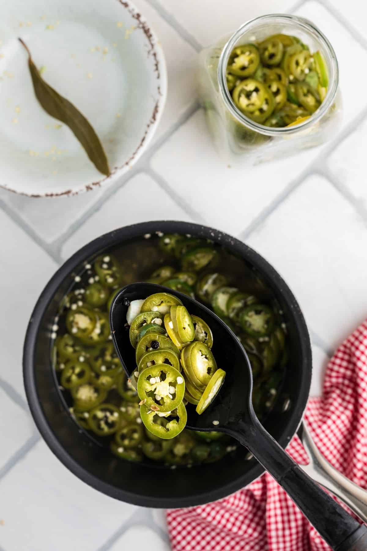 Jalapenos after soaking in the brine solution and changing color to a more olive green.