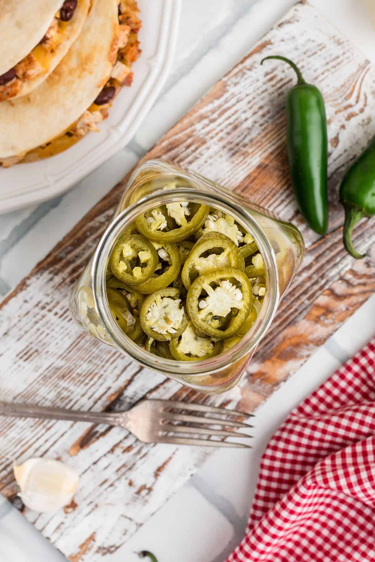 A jar of finished pickled jalapenos shot from above.