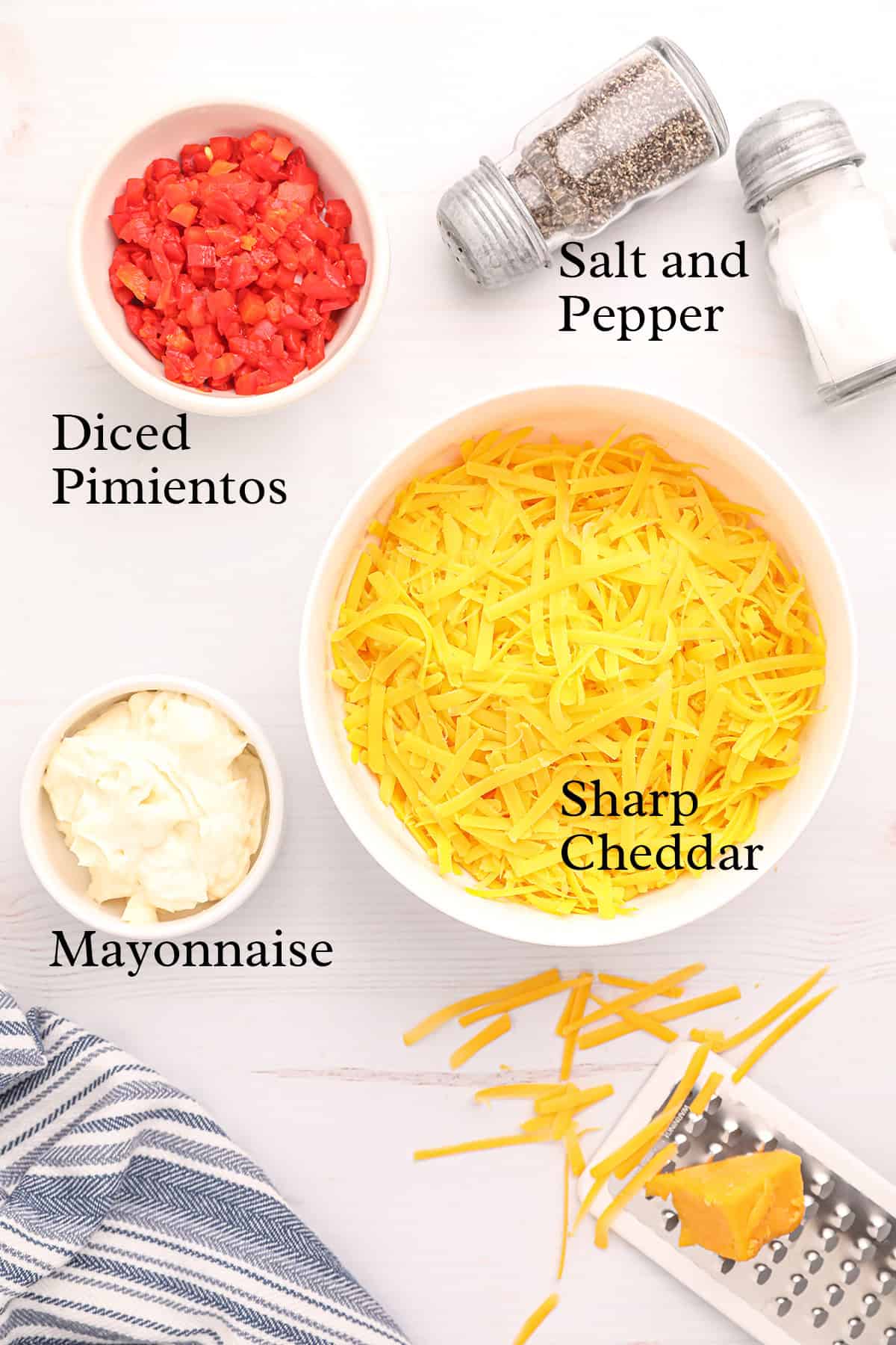Shredded cheddar, diced pimientos, mayo, salt, and pepper on a white surface with labels for each item.
