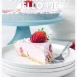 Slice of strawberry jello pie with a fresh strawberry on top, served on stacked white plates with a fork.