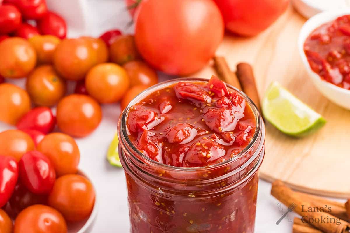 Finished tomato jam in a glass jar.