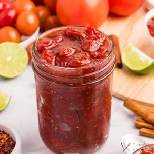 Finished tomato jam in a glass jar.
