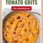 A skillet of cheesy tomato grits with melted cheese on top, labeled Cheesy Tomato Grits.