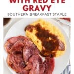 Plate with sliced country ham, yellow grits topped with red eye gravy, and a bit of sauce on the side.