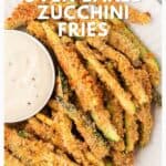 Plate of oven-baked zucchini fries with a side of dipping sauce, viewed from above.