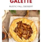 A rustic pear galette on parchment paper with honey and sauce, styled as a cozy fall dessert.