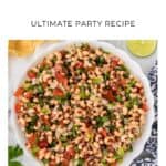 Bowl of Texas caviar with black-eyed peas, tomatoes, herbs, and a lime slice on the side.