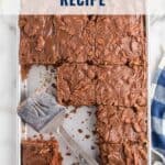A sliced chocolate sheet cake with a metal spatula on a baking tray, labeled Texas Sheet Cake Recipe.