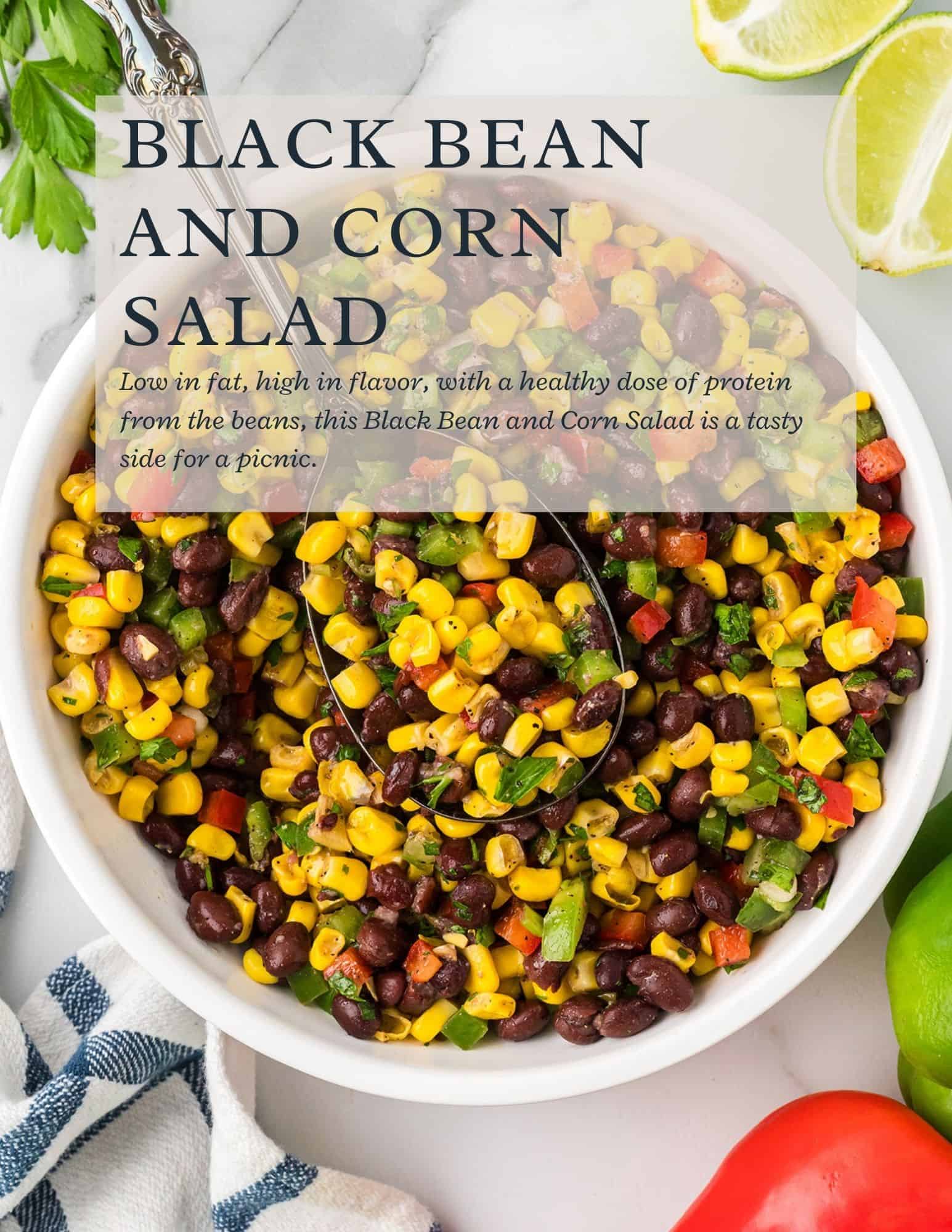 A white bowl filled with black bean and corn salad with chopped red and green bell peppers, cilantro, and a serving spoon. Text overlay describes the salad as low fat, high in flavor, and a good picnic side.